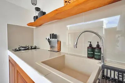 a white kitchen with a sink and a counter at Robelle Villa by iBali Management in Seminyak