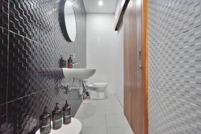 a bathroom with a sink and a toilet and a mirror at Robelle Villa by iBali Management in Seminyak