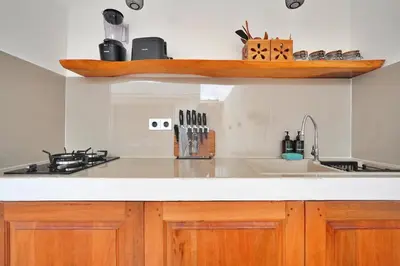 a kitchen with wooden cabinets and a counter top at Robelle Villa by iBali Management in Seminyak
