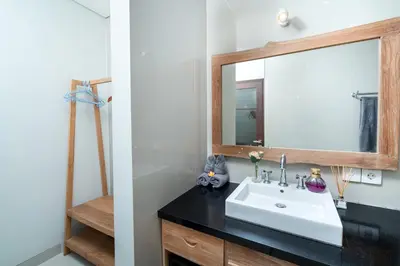a bathroom with a sink and a mirror at Honeymoon Villa Aisha in The Heart of Legian in Seminyak