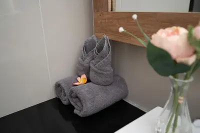 a couple of towels with flowers in a vase at Honeymoon Villa Aisha in The Heart of Legian in Seminyak