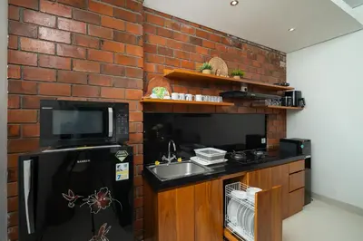 a kitchen with a sink and a brick wall at Honeymoon Villa Aisha in The Heart of Legian in Seminyak