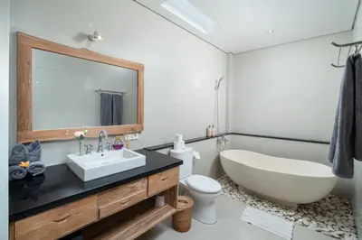 a bathroom with a tub and a sink and a toilet at Honeymoon Villa Aisha in The Heart of Legian in Seminyak