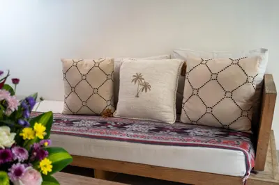 a bench with pillows on it next to flowers at Honeymoon Villa Aisha in The Heart of Legian in Seminyak