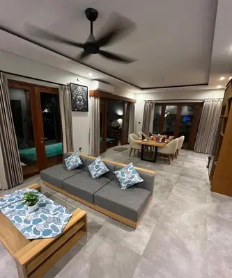 a living room with a couch and a table at Villa Dharman Jimbaran in Jimbaran