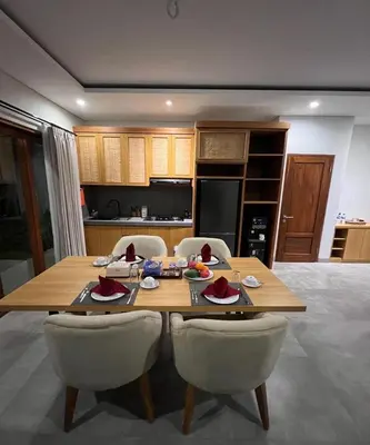 a kitchen with a wooden table and chairs at Villa Dharman Jimbaran in Jimbaran