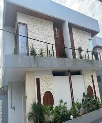 a house with a balcony with plants on it at Villa Dharman Jimbaran in Jimbaran