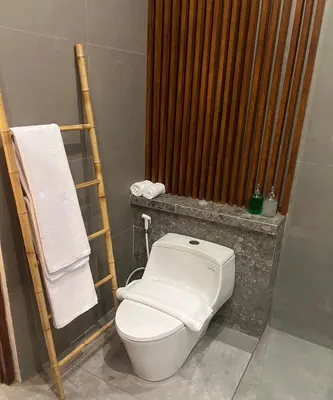 a bathroom with a toilet and a towel rack at Villa Dharman Jimbaran in Jimbaran