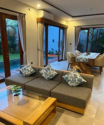a living room with a couch and a table at Villa Dharman Jimbaran in Jimbaran