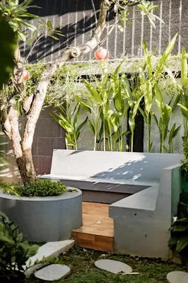 a garden with a bench and a tree and plants at Casa Raya 4BR Villa in Kuta in Kuta