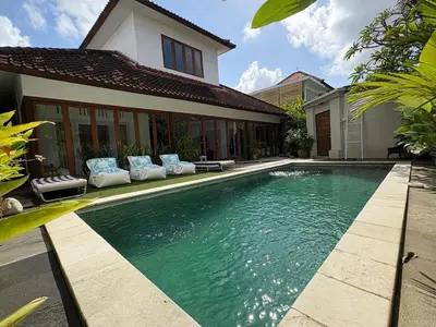 a swimming pool in front of a house at Villa central seminyak in Seminyak