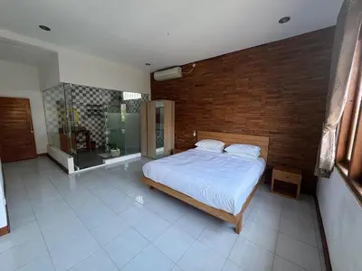 a bedroom with a bed and a brick wall at Villa central seminyak in Seminyak