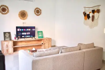 a living room with a couch and a flat screen tv at Villa 2BR Seminyak 8mins Beach in Seminyak