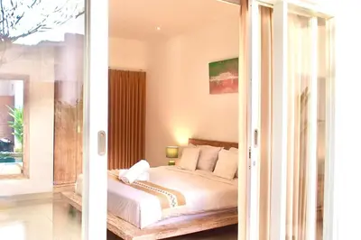 two pictures of a bedroom with a bed and a window at Villa 2BR Seminyak 8mins Beach in Seminyak