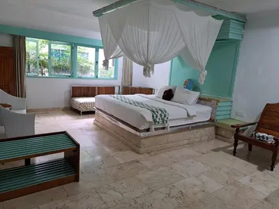 a bedroom with a bed and a room with a couch at Lavender Villa 7 Moon House in Kuta
