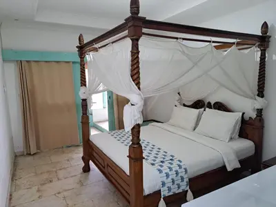 a bedroom with a canopy bed with white sheets at Lavender Villa 7 Moon House in Kuta
