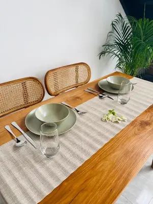 a wooden table with two plates and glasses on it at Arden Loft in Kerobokan