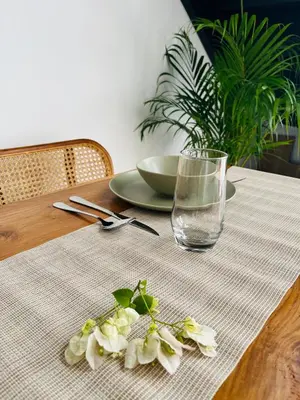 a table with a glass of water and flowers on it at Arden Loft in Kerobokan