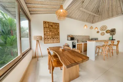 a kitchen and dining room with a wooden table and chairs at Villa Anna Lou 1BR Boho Escape in Seminyak in Seminyak