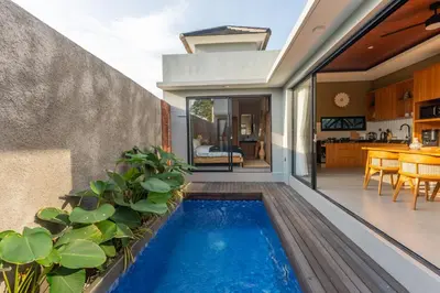 a swimming pool in the middle of a house at Villa Sattvika in Kerobokan
