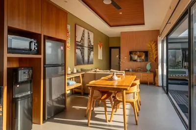 a kitchen with a wooden table and a dining room at Villa Sattvika in Kerobokan