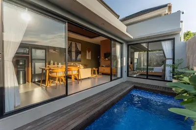 an internal view of a house with a swimming pool and a dining room at Villa Sattvika in Kerobokan
