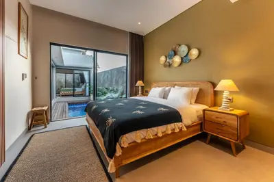 a bedroom with a bed and a large window at Villa Sattvika in Kerobokan