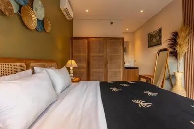 a bedroom with a bed with white pillows at Villa Sattvika in Kerobokan