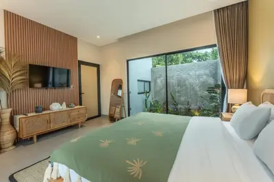 a bedroom with a large bed and a large window at Villa Sattvika in Kerobokan