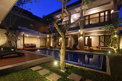 a villa with a swimming pool at night at Djayana Villa Seminyak in Seminyak