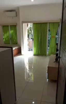 a living room with green curtains and a table at Dewata ayu resident in Seminyak