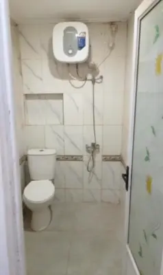 a small bathroom with a toilet and a shower at Dewata ayu resident in Seminyak