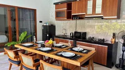 a kitchen with a wooden table with plates on it at Villa Sakura Nisa in Seminyak