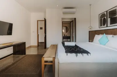 a bedroom with a large white bed and a tv at Villa Casa Rumi in Canggu