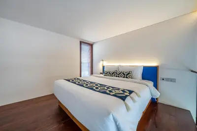 a bedroom with a large white bed with a window at First 5 Bedrooms Villa in Seminyak