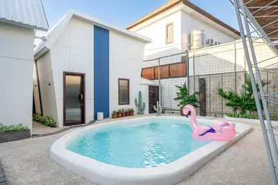 a swimming pool with a pink flamingo in front of a house at First 5 Bedrooms Villa in Seminyak