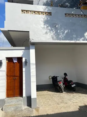 a white building with two motorcycles parked next to it at Hidden Homestay Jimbaran in Jimbaran