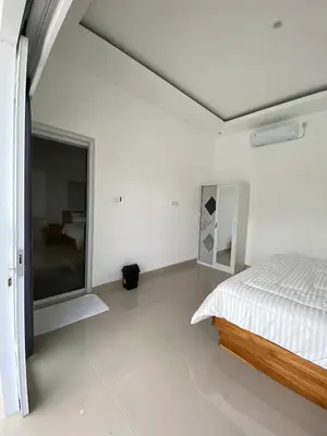 a bedroom with a bed and a large window at Hidden Homestay Jimbaran in Jimbaran