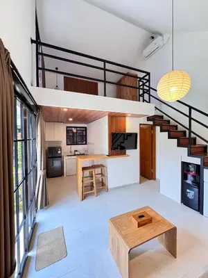 a living room with a staircase and a table at Kubumanik Loft in Seminyak