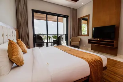 a bedroom with a large white bed and a television at Villa By The Sea with private swimming pool in Benoa - Nusa Dua in Ujung