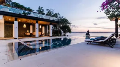 a house with a swimming pool next to the ocean at Villa By The Sea with private swimming pool in Benoa - Nusa Dua in Ujung