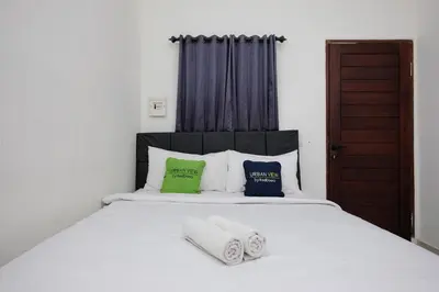 a bedroom with a white bed with towels on it at Urbanview Hotel Arta Guna Casa in Kerobokan