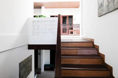 a staircase in a house with wooden floors at Urbanview Hotel Arta Guna Casa in Kerobokan