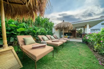 a row of chairs and tables in a yard at Sweet Surrender - Stylish 4BR Near Potato Head in Seminyak