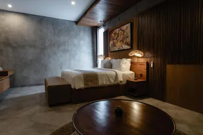 a hotel room with a bed and a table at Dharman Royal Villas in Kerobokan