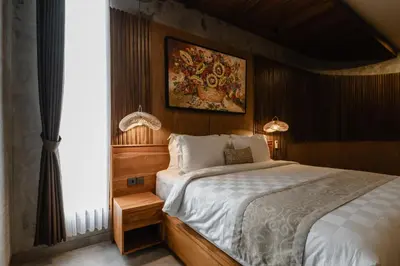 a bedroom with a bed and a painting on the wall at Dharman Royal Villas in Kerobokan