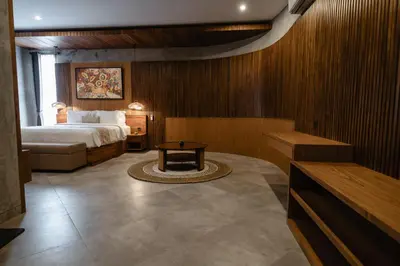 a hotel room with a bed and a table at Dharman Royal Villas in Kerobokan