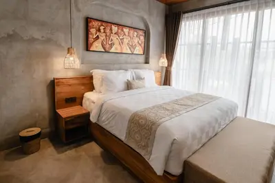 a bedroom with a bed and a painting on the wall at Dharman Royal Villas in Kerobokan