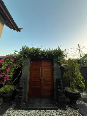 a wooden door with plants on the side of a house at Ohara Hideway 3BR Japanese Vibes Villa in Kerobokan Seminyak Bali in Seminyak