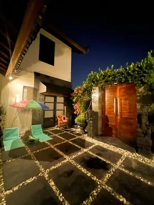 a patio with chairs and an umbrella in front of a house at Ohara Hideway 3BR Japanese Vibes Villa in Kerobokan Seminyak Bali in Seminyak